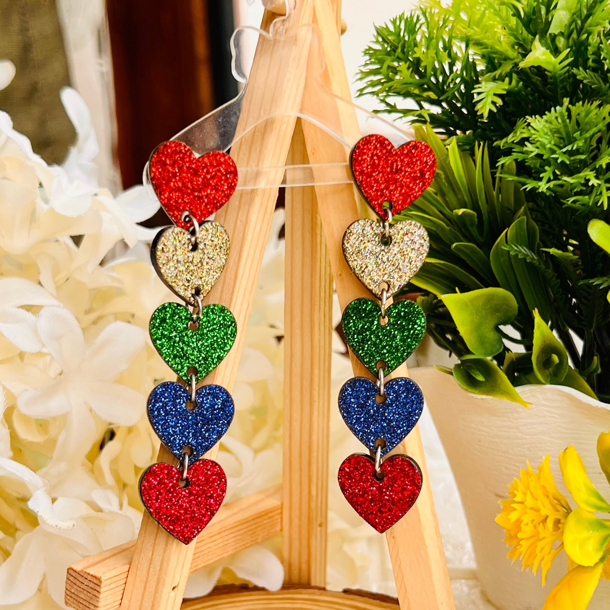 These Rainbow Glitter Heart Earrings will be sure to make a statement. Featuring a unique glitter design, these earrings will sparkle and shine. Perfect for any occasion, these earrings will make sure you stand out.