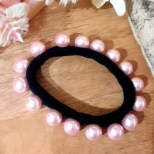 Our Pink Pearl Hair-tie is a stylish solution to keep your hair out of your face. It's made with pretty pink beads and elastic so it's comfortable and won't snag your hair when you wear it. Perfect for any occasion, it's sure to become your go-to hair accessory.