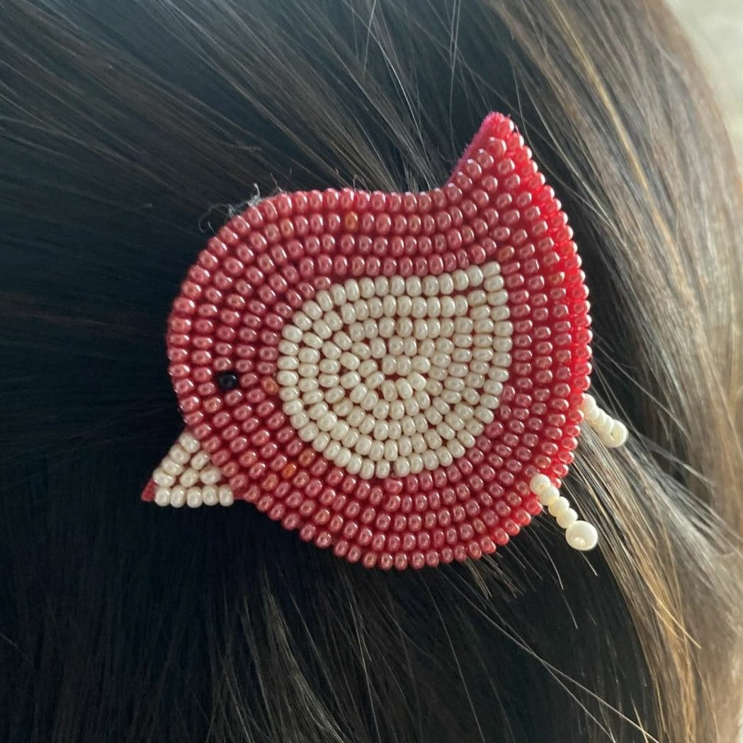 This handmade red beaded birdie hairclip adds a vibrant pop of color to any hairstyle. The bird is crafted from beading techniques used by artisans, so you can be sure the quality is superb. Fasten your look with this unique and stylish accessory for a look that will turn heads.