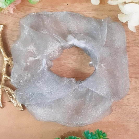 This Silver Organza Scrunchie features a shiny and light material, perfect for adding the perfect touch of glamour to any outfit. Crafted with care, this scrunchie is sure to make you stand out.