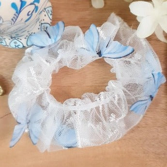 This stylish Blue 3D Butterfly Scrunchie adds an eye-catching and fun touch to any look. The white net features delicate blue butterflies bringing a whimsical and unique element to your hair. The perfect addition to spruce up any outfit!