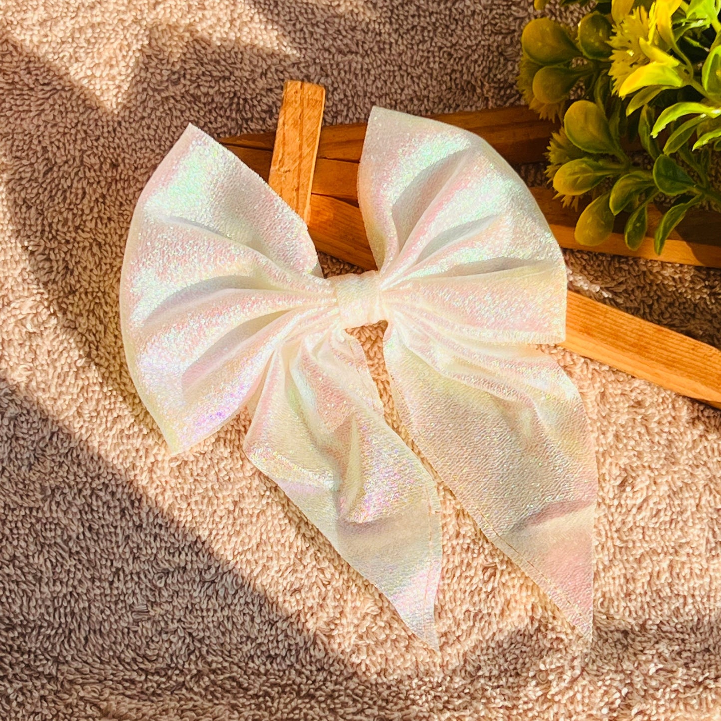 This Lemon Holographic Bow is sure to make a statement. It is made up of a shinny lemon bow, enveloped in eye-catching, radiant holographic colours. It is the perfect accessory for any occasion and is sure to turn heads.