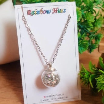 Let your style sparkle with this charming Silver Star Shaker Globe Necklace! Embellished with a mesmerizing array of shiny silver star sequins, this delicate glass globe pendant will capture the light with every move. Perfect for any special occasion or everyday wear, this beautiful necklace will add a touch of glamour to any look!