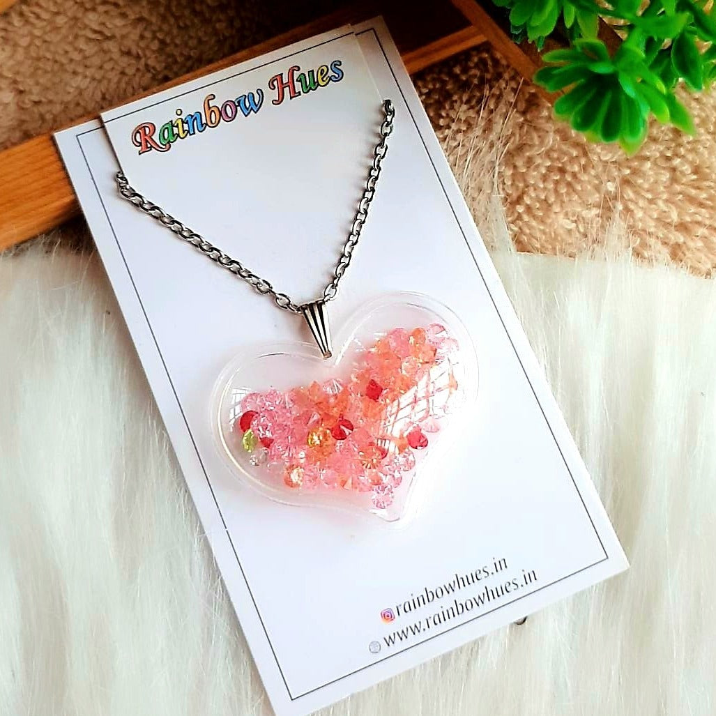 Adorn yourself with exquisite beauty in our Jewel Heart Shaker Necklace. This charming necklace features a beautiful heart filled with precious stone jewels, perfect for adding a sparkle to any look. Show off your unique style and enjoy the elegance of our Jewel Heart Shaker Necklace!