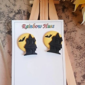 Adorn your ears with these mysterious Haunted House Stud Earrings! Featuring a unique design of a haunted house, moon, and bat, these earrings are perfect for making a bold statement. Show off your individuality with these cool studs and stand out from the crowd.